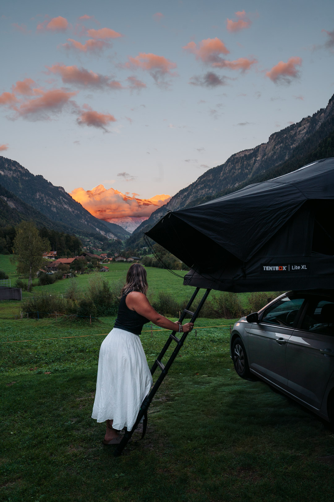 Installation de l'échelle de la tente de toit TentBox Lite XL pendant un road trip en Suisse
