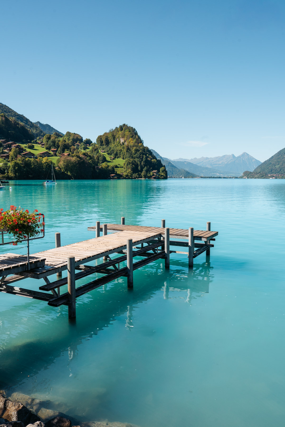 Ponton en bois sur les eaux turquoise du lac de Brienz à Iseltwald, avec les montagnes suisses en arrière-plan