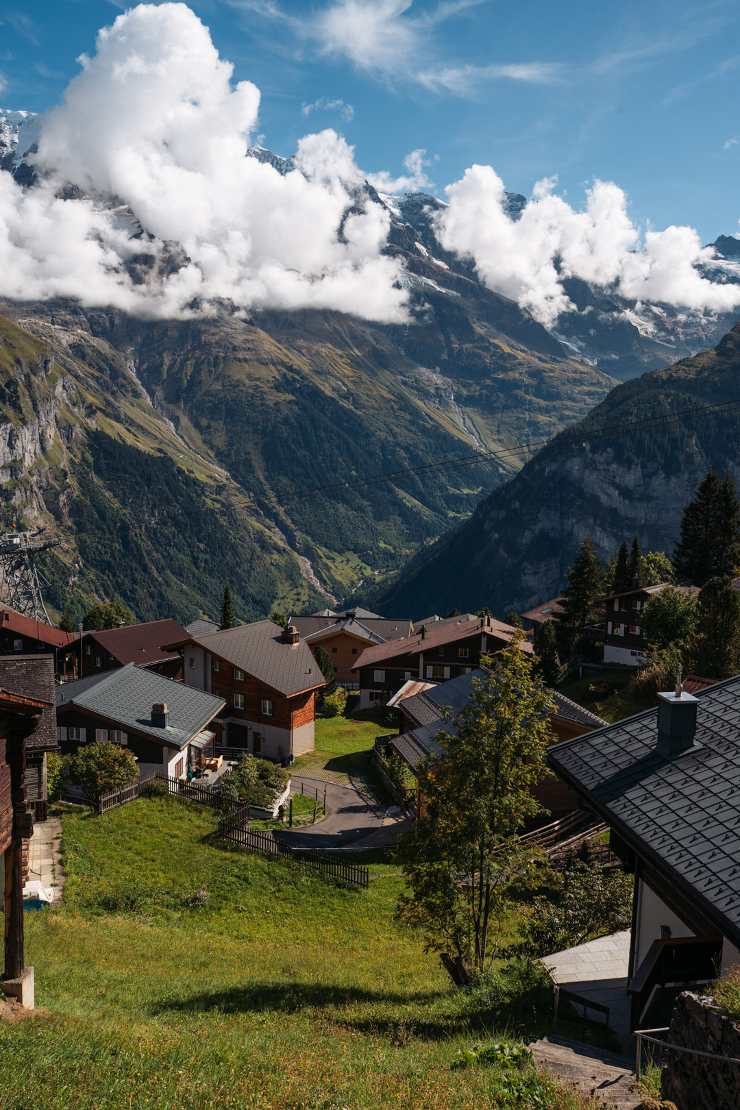 Chalets traditionnels du village de Mürren, avec les montagnes des Alpes suisses et les nuages en arrière-plan